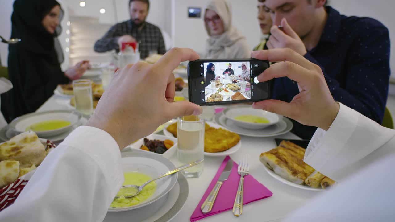 Keluarga Muslim makan dan minum halal, seorang pria mengambil foto dengan ponsel.