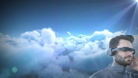 caucasian man wearing vr goggles against spot of light and clouds in the sky