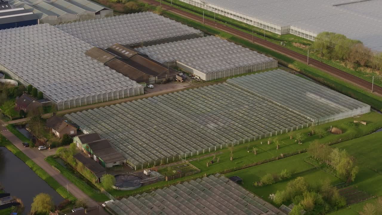 Heerhugowaard, Hollanda'da demiryolu hatları ve tarlaların yanındaki seralar.