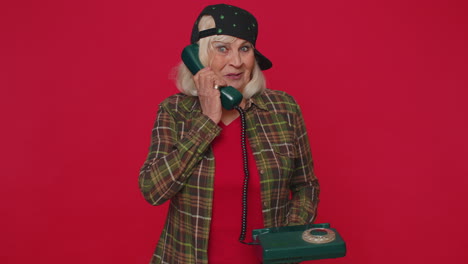 Cheerful-tourist-woman-secretary-talking-on-wired-vintage-telephone-of-80s,-say-Hey-You-Call-Me-Back