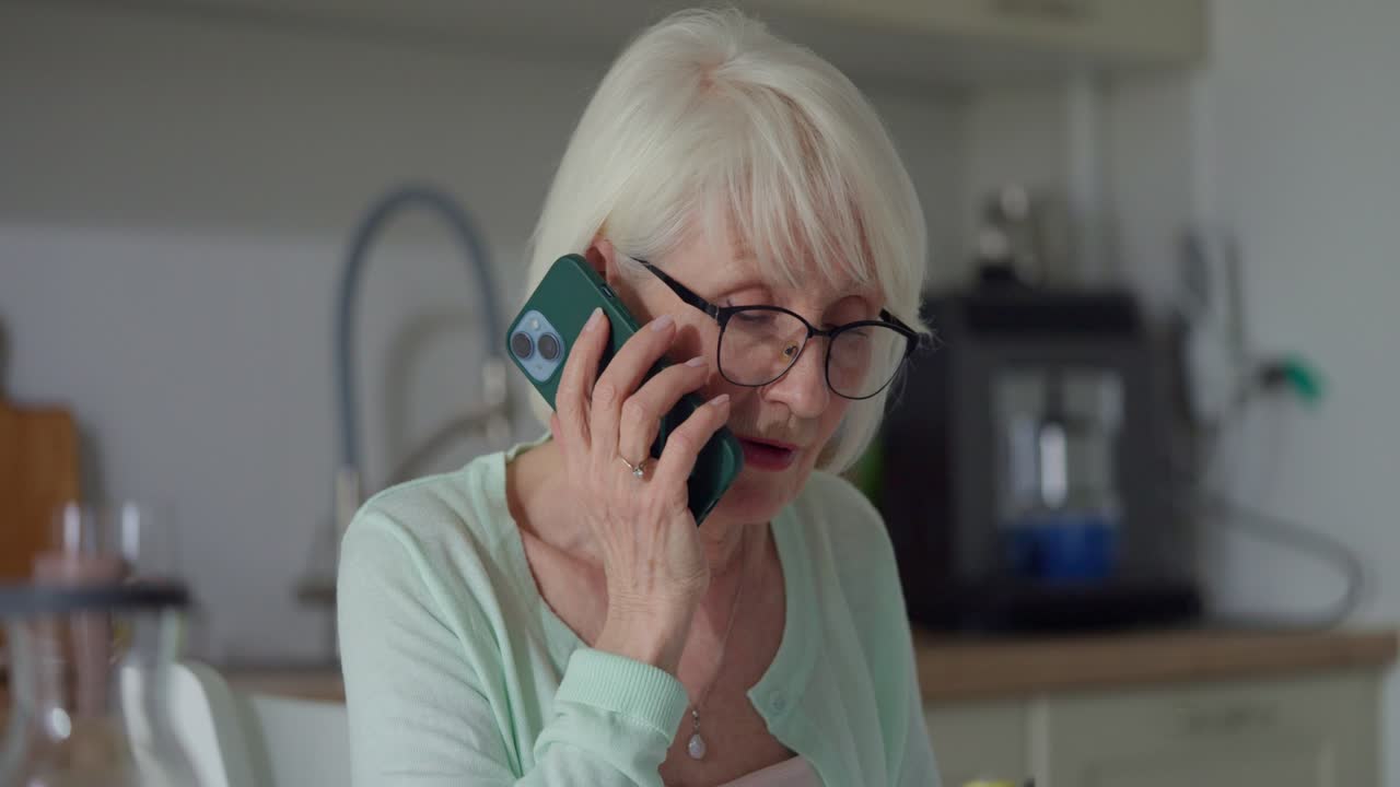 Senior woman on a phone call in the kitchen