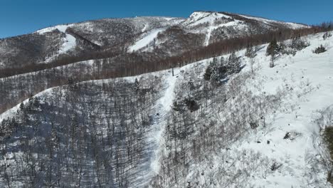 Aufsteigender-Drohnenschuss,-Der-In-Richtung-Der-Japanischen-Ski-Seilbahn-Fliegt-Und-Den-Berg-Hinaufführt