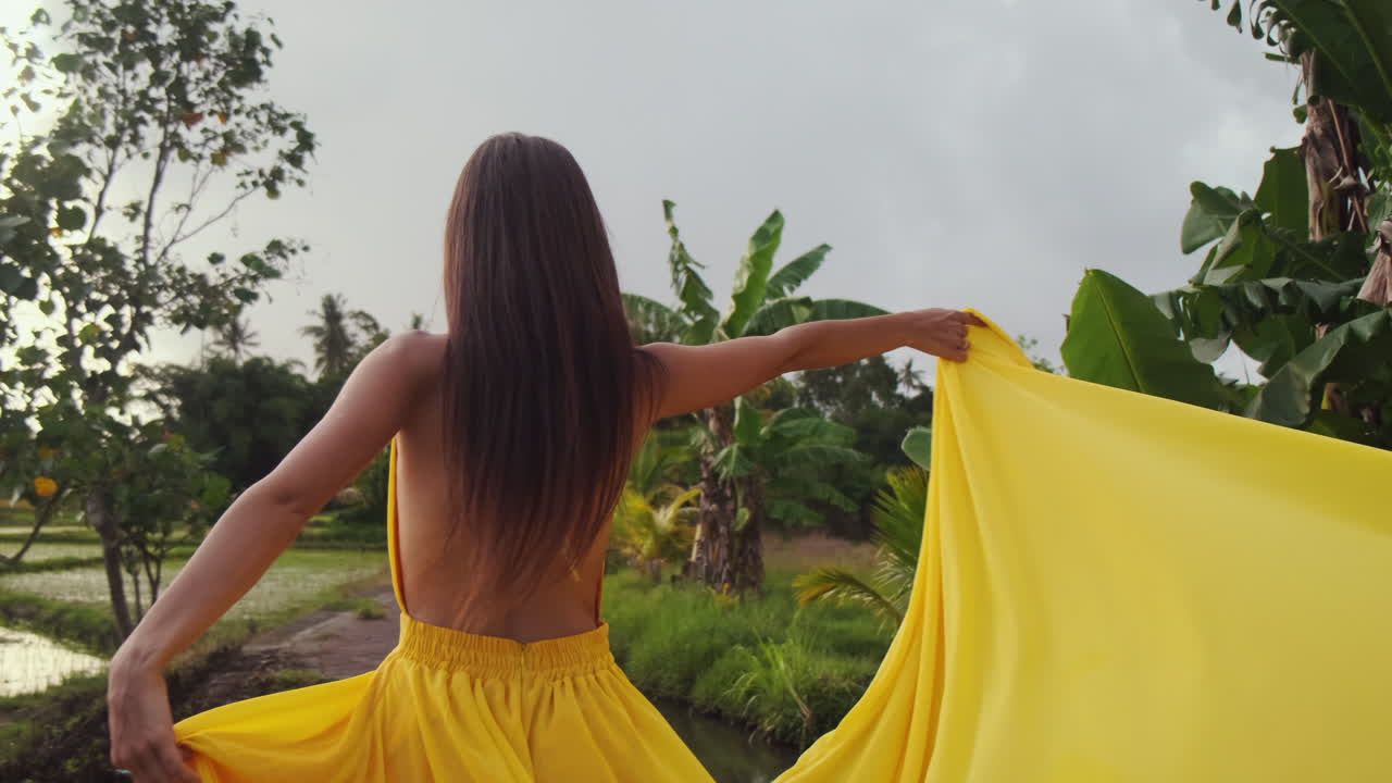Woman in a Yellow Dress in a Tropical Setting