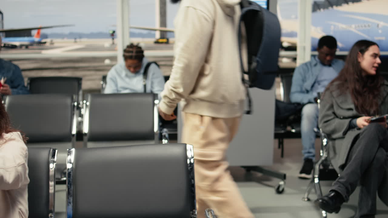 Woman and friend in airport discussing flight itinerary, sitting on chairs
