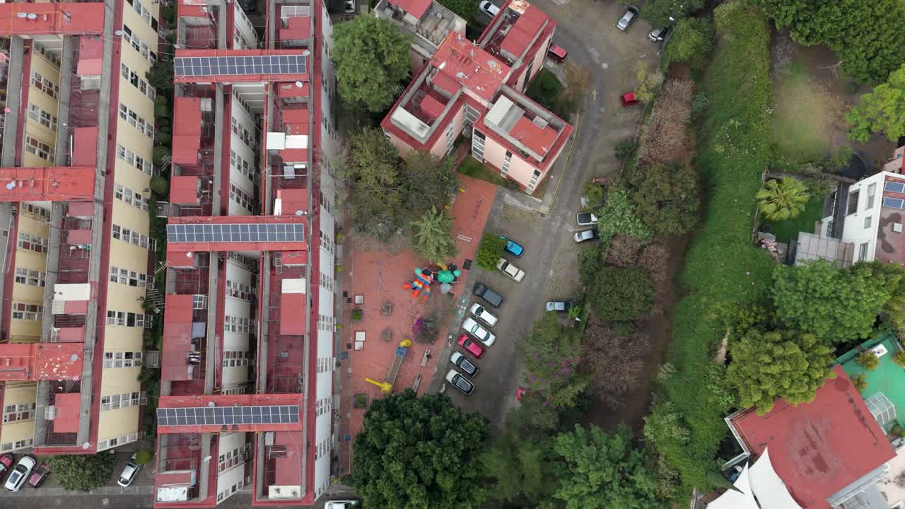 Drone flies above a housing development, with parks and children's play areas in view