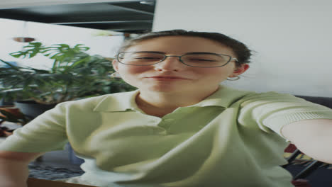 girl waving and talking on camera at home