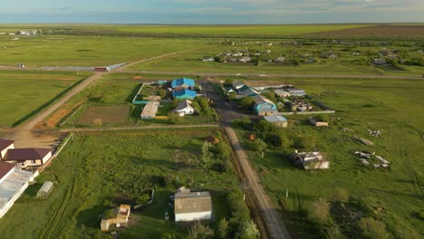 Houses-Situated-in-Green-Fields-Next-to-Dirt-Roads-in-Kazakhstan,-Central-Asia---Drone-Flying-Forward