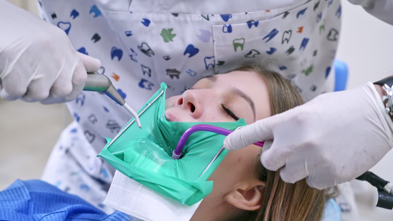Woman in stomatology clinic. Doctor treats patient teeth in modern dental clinic