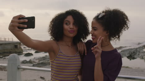 Hermosas-Hermanas-Gemelas-Hispanas-Posando-Felices-Tomando-Selfies-Usando-El-Teléfono-Divirtiéndose