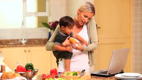 busy woman phoning and dealing with her baby and her laptop