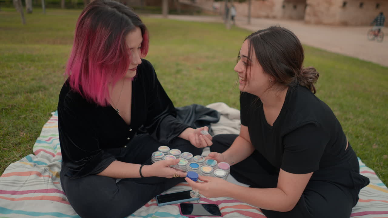 Two Women Having a Conversation in a Park, Discussing Makeup