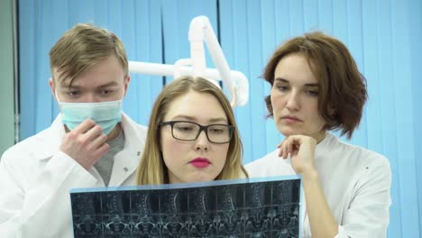 profesionales dentales que revisan las radiografías