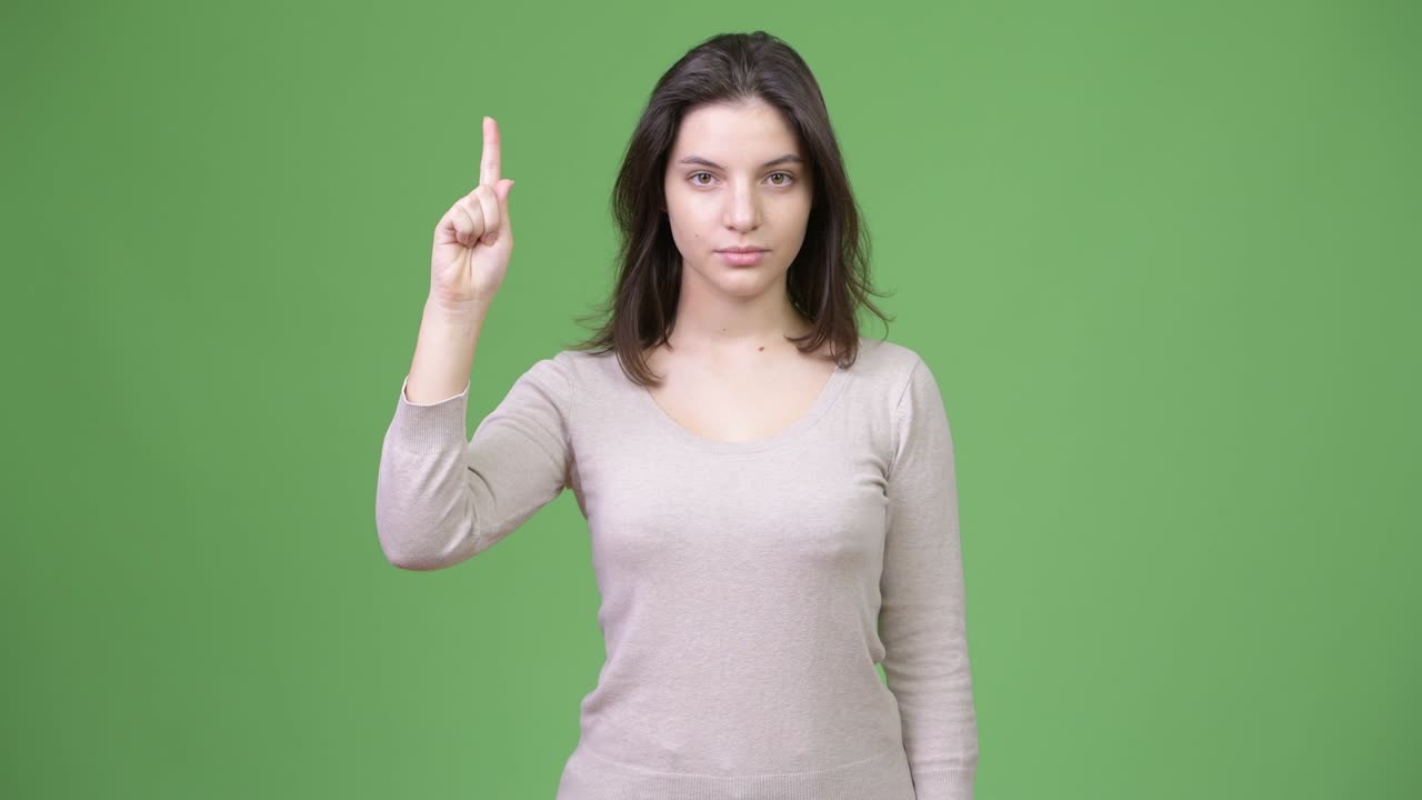 Young beautiful woman pointing finger up