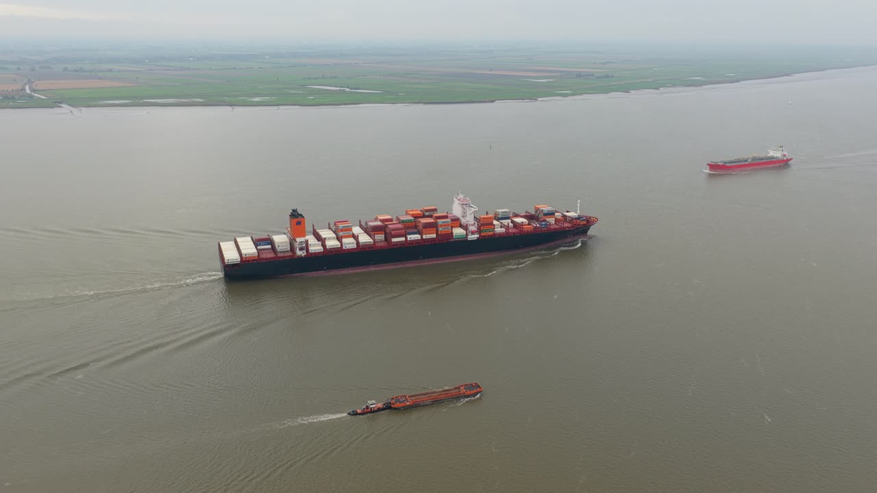 Freight container ship navigating Germany Elbe River, drone footage