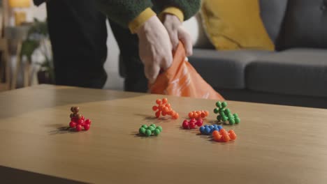 persona ordenando un rompecabezas de forma entrelazada de colores en la mesa en casa para un niño diagnosticado con tea