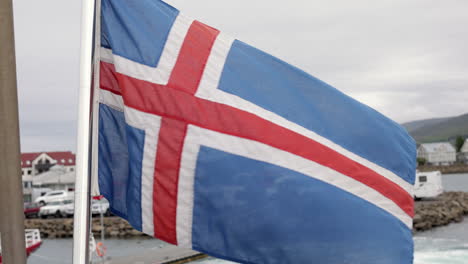 flag of iceland waving in the wind on a ship leaving a harbor, close up shot