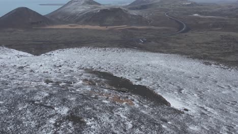 snowy landscape with volcanic mountain cones in spectacular iceland terrain, aerial