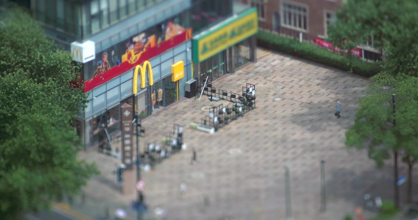High Angle Tilt-Shift View of Pedestrians Walking Near a McDonald's Restaurant