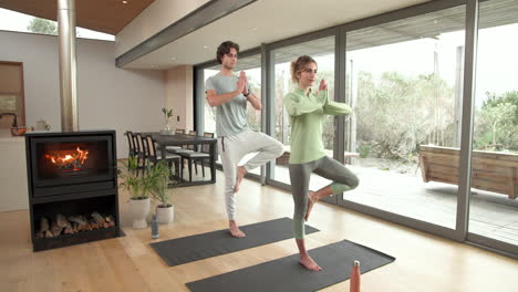 couple practicing yoga together at home near cozy fireplace, enjoying relaxation