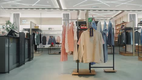 shopping clothing store interior. modern fashionable shop, clothes for every taste. stylish brand design, fashionable colors, quality sustainable materials. no people. low dolly establishing shot