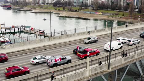 Kanadische-Flaggen-Auf-Autos-Mit-Passanten-An-Der-Burrard-Brücke-Während-Des-Trucker-Konvoi-Protestes-In-Vancouver,-Kanada