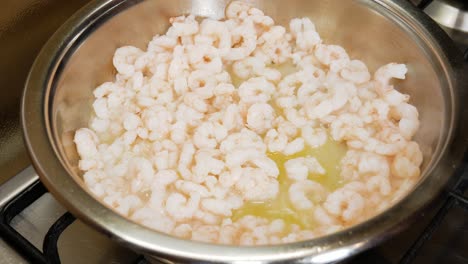 pequeños camarones frescos y humeantes se están cocinando en una olla de metal