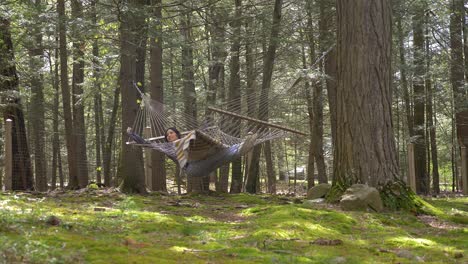 cómoda mujer puertorriqueña balanceándose en una hamaca en el bosque disfrutando de la vida escapando