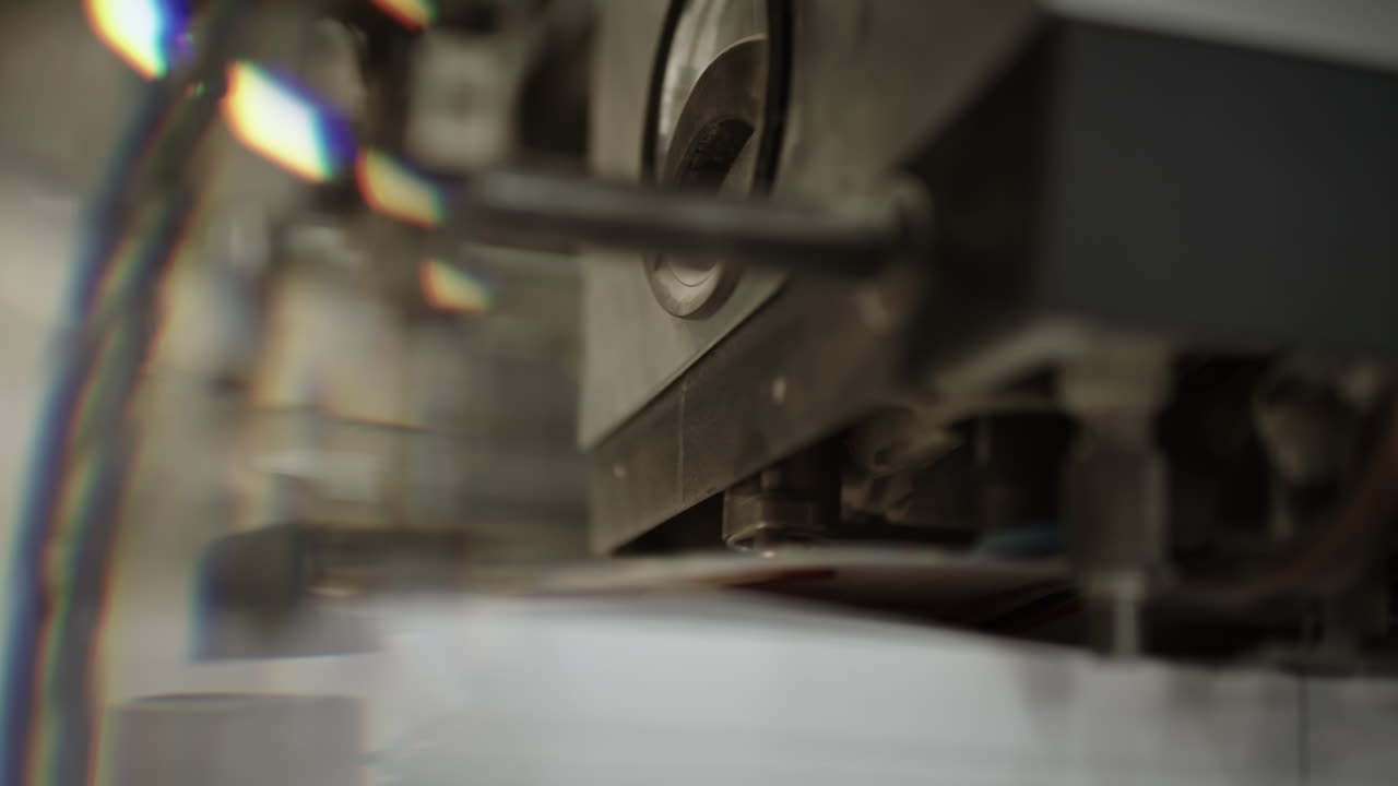 인쇄 기계의 클로즈업, 기계의 일부가 종이 한 장을 들어 올려 앞으로 보내는 세부 사항