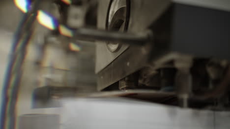 close up of a printing machine, a detail where a part of machine lifts a sheet of paper and sends it forward