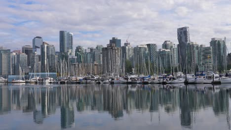 Puerto-Deportivo-Con-El-Horizonte-Del-Centro-De-Vancouver-Al-Fondo-Reflejándose-En-El-Agua-En-BC,-Canadá