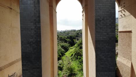 drone volando bajo el puente en el valle de la naturaleza de malta