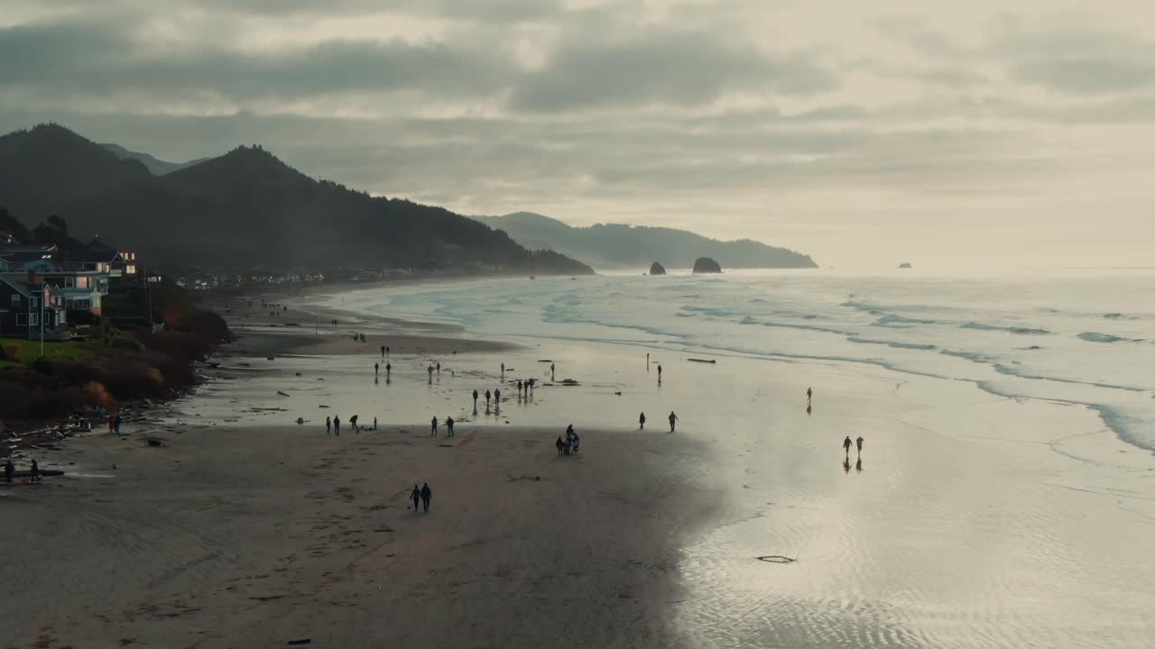 4k Aerial People walking on the beach on cloudy day Drone dolly in + Jib down