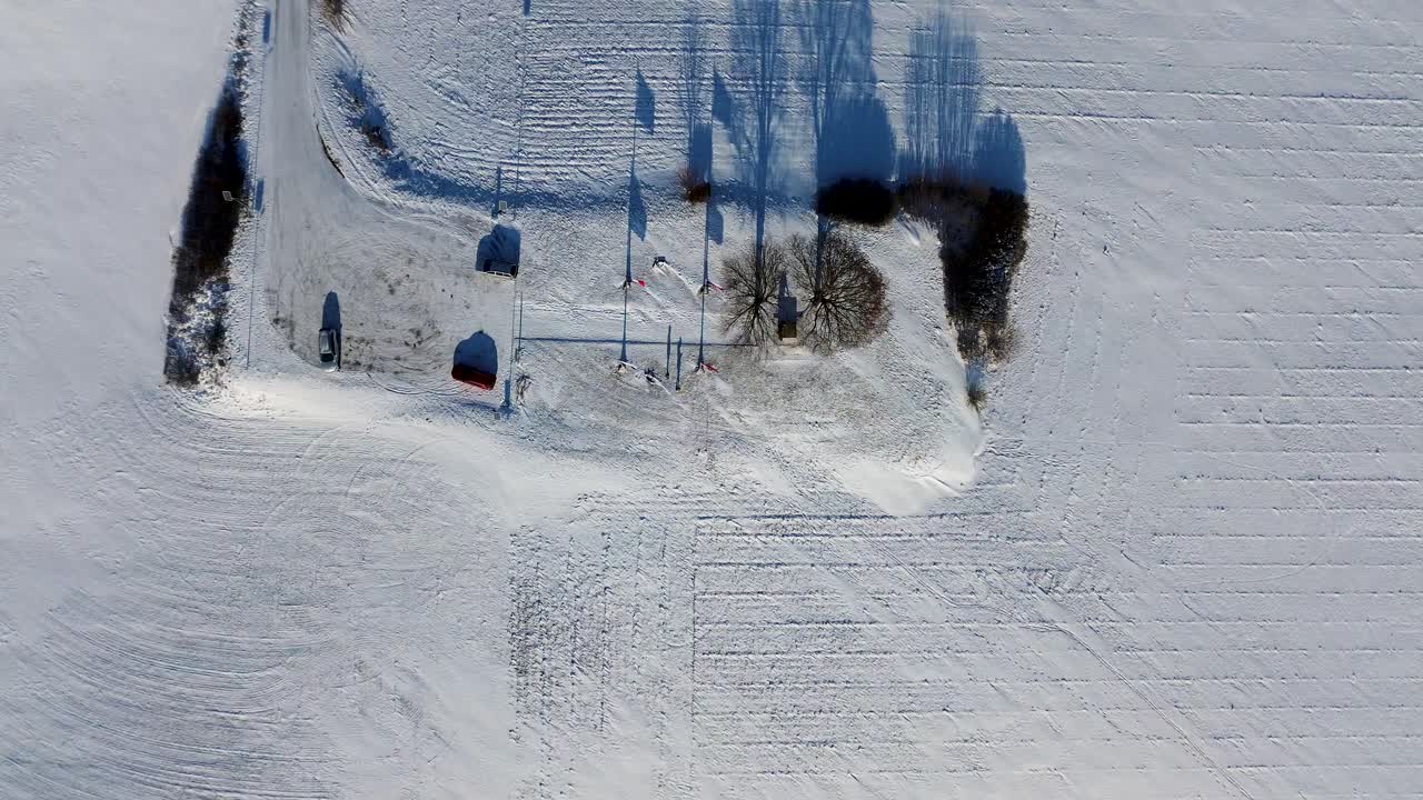 una vista desde arriba de un paisaje cubierto de nieve y una colina nevada en el fondo