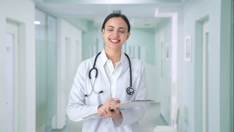 happy indian female doctor writing medicines for patient