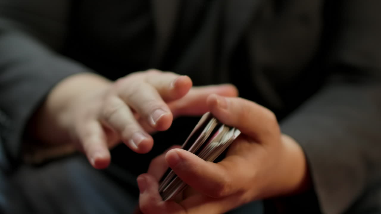 Slow motion closeup of a skilled player's hands shuffling a deck of cards