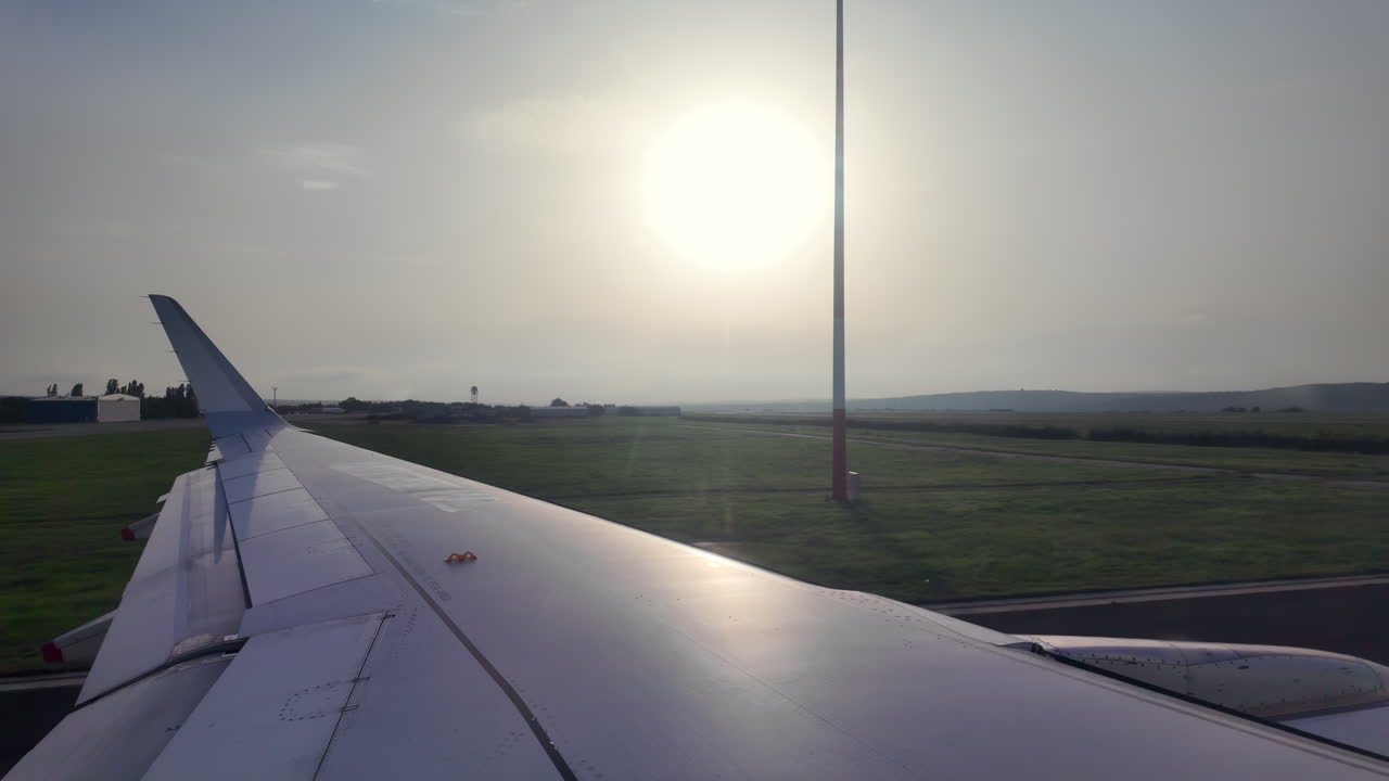 Chisinau, Moldova - July 12, 2025: View of the airplane wing from window seat moving through the Chisinau International Airport