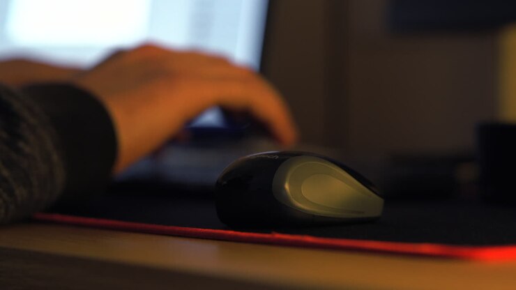 Uomo che digita al computer con messa a fuoco sul mouse.