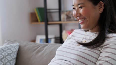 Happy-Pregnant-Asian-Woman-with-Laptop-at-Home.pregnancy,-rest,-people-and-expectation-concept--happy-smiling-pregnant-asian-woman-with-laptop-computer-sitting-on-sofa-at-home