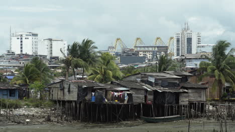 wide shot of stilt houses in foreground and city buildings in the background of buenaventura