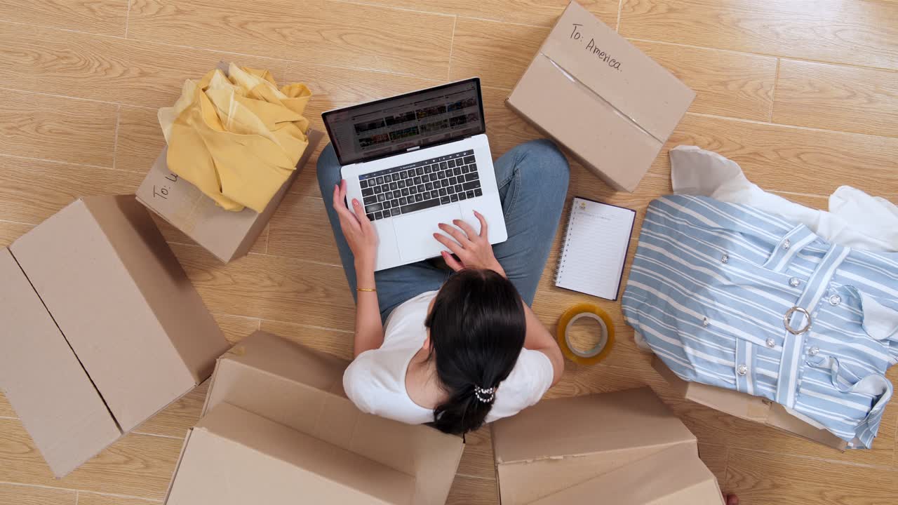 Woman working from home while packing for a move