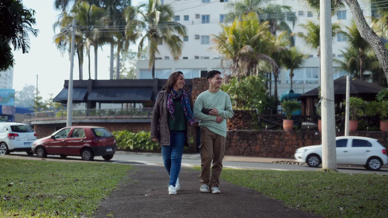 Mother and son walking and conversing on a city street