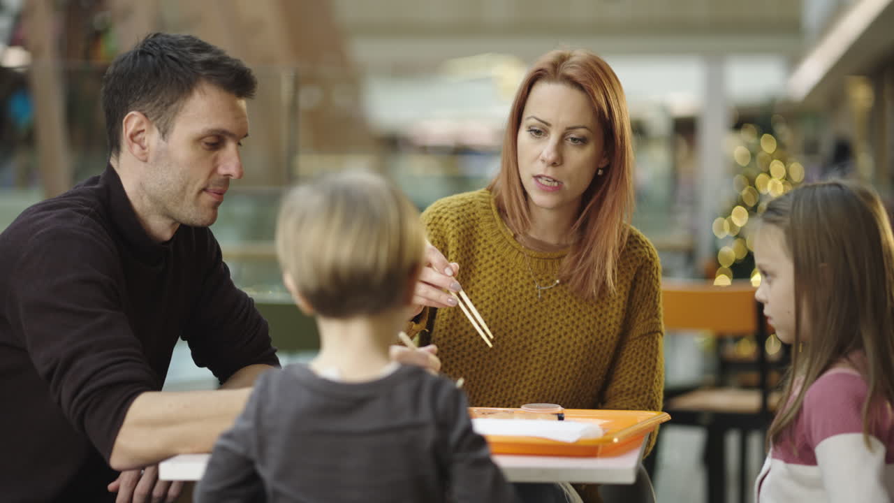 Famiglia che mangia insieme in un'area ristorazione