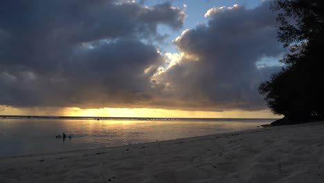 sunset on rarotonga island with colored clouds, sandy beaches and ocean waves