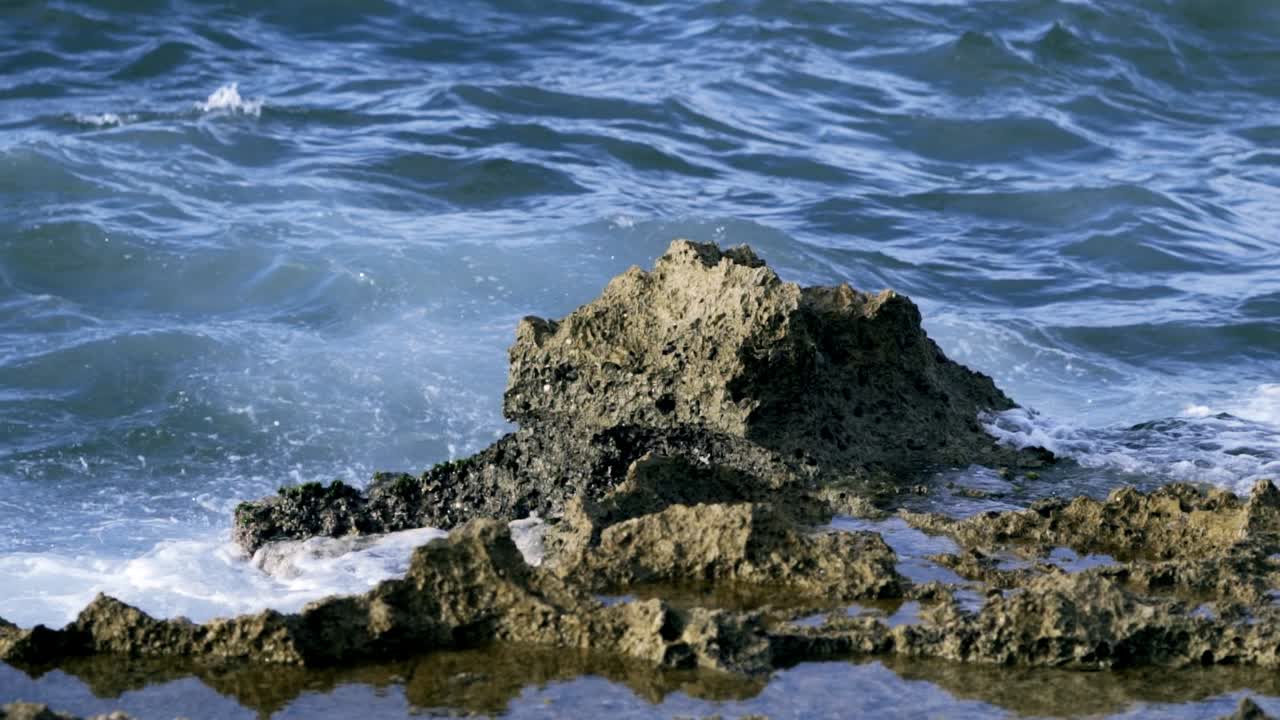 Le onde dell'oceano si scontrano con le rocce