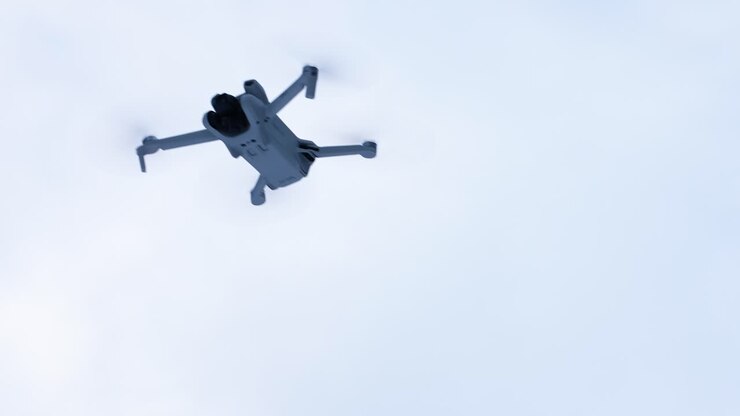 Drone flying in the air, the video is shot from the ground handheld