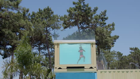 niño nadando en un recipiente transparente de la piscina