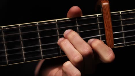 detail shot of guitarist hand on neck of the guitar while playing guitar