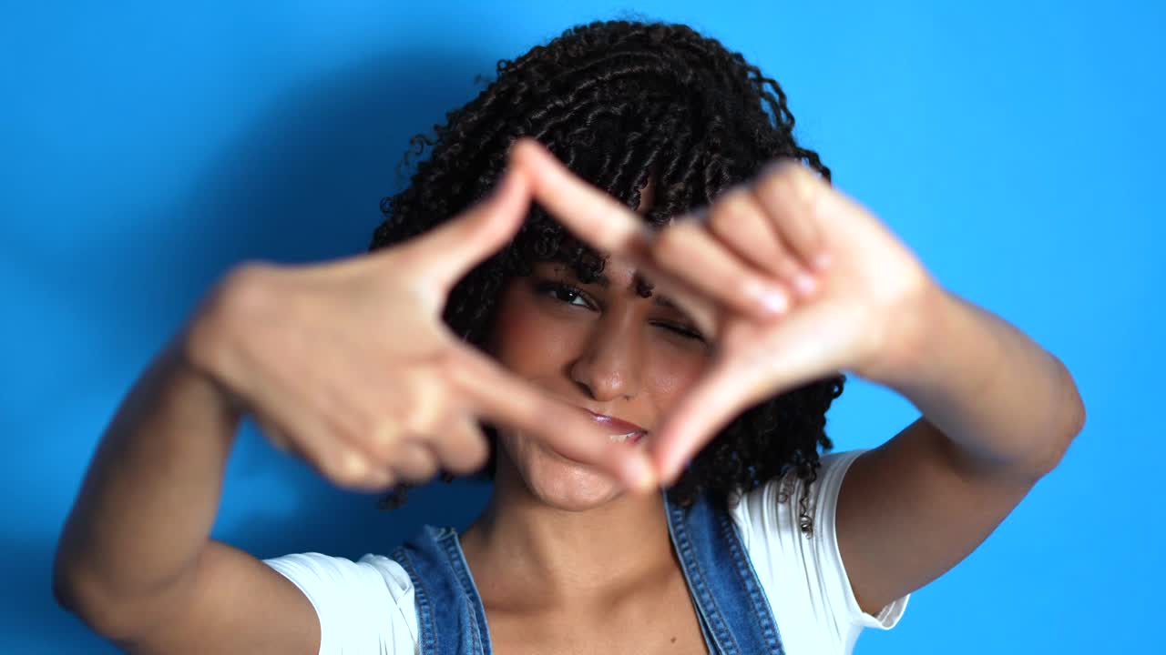 Portrait of a smiling woman making a frame with her hands