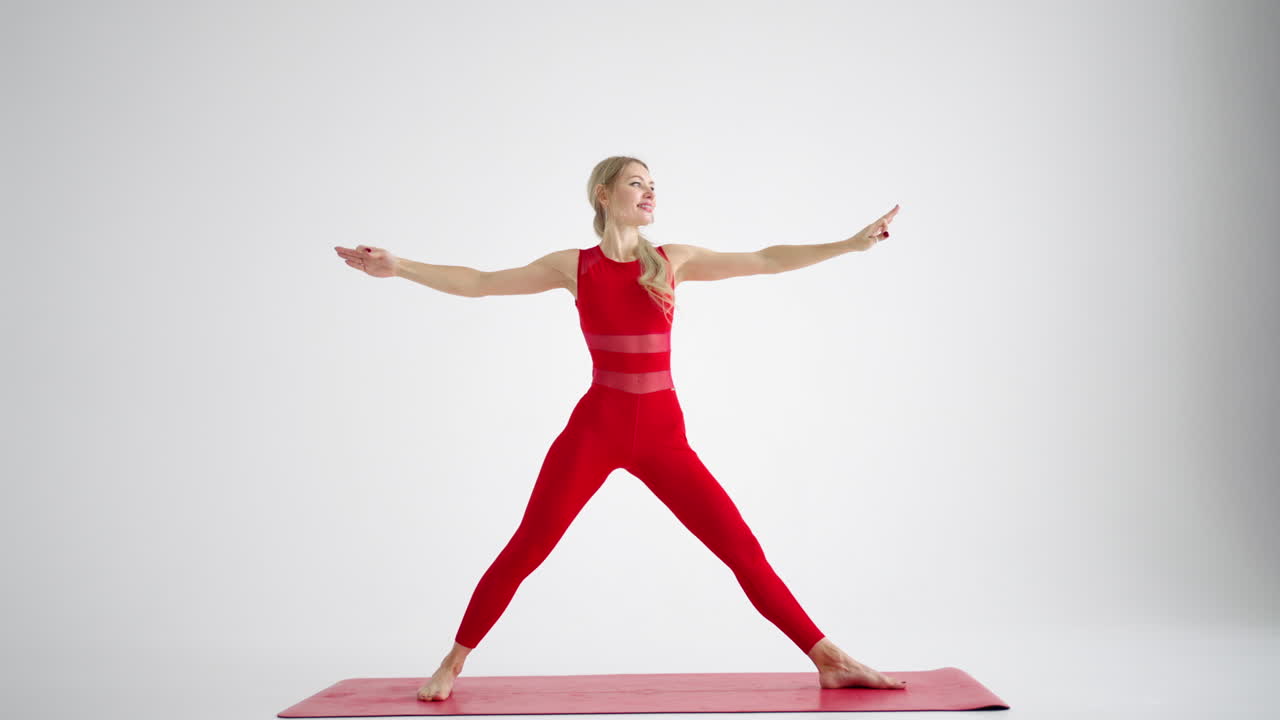 Young woman shows yoga or pilates exercises. Young attractive woman practicing yoga in studio. Girl shows different poses for yoga in white background. Healthy lifestyle yoga in my heart sports