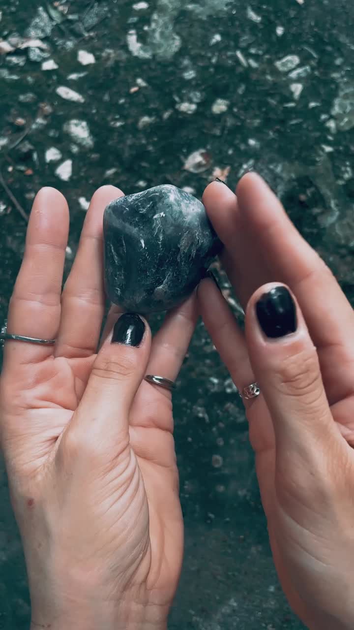 Woman holding a grey stone in her hands